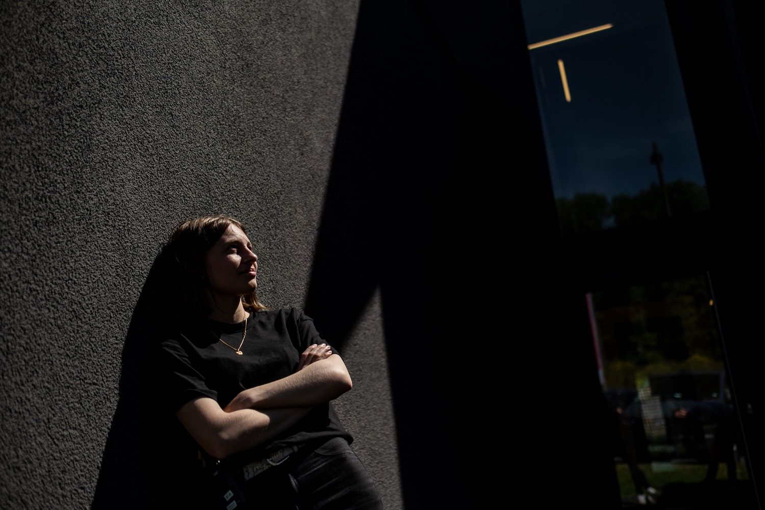 Jetzt entspannt Kontakt aufnehmen für Content, Social Media und Contentproduktion - Frau liegt an wand mit tollem Schatten