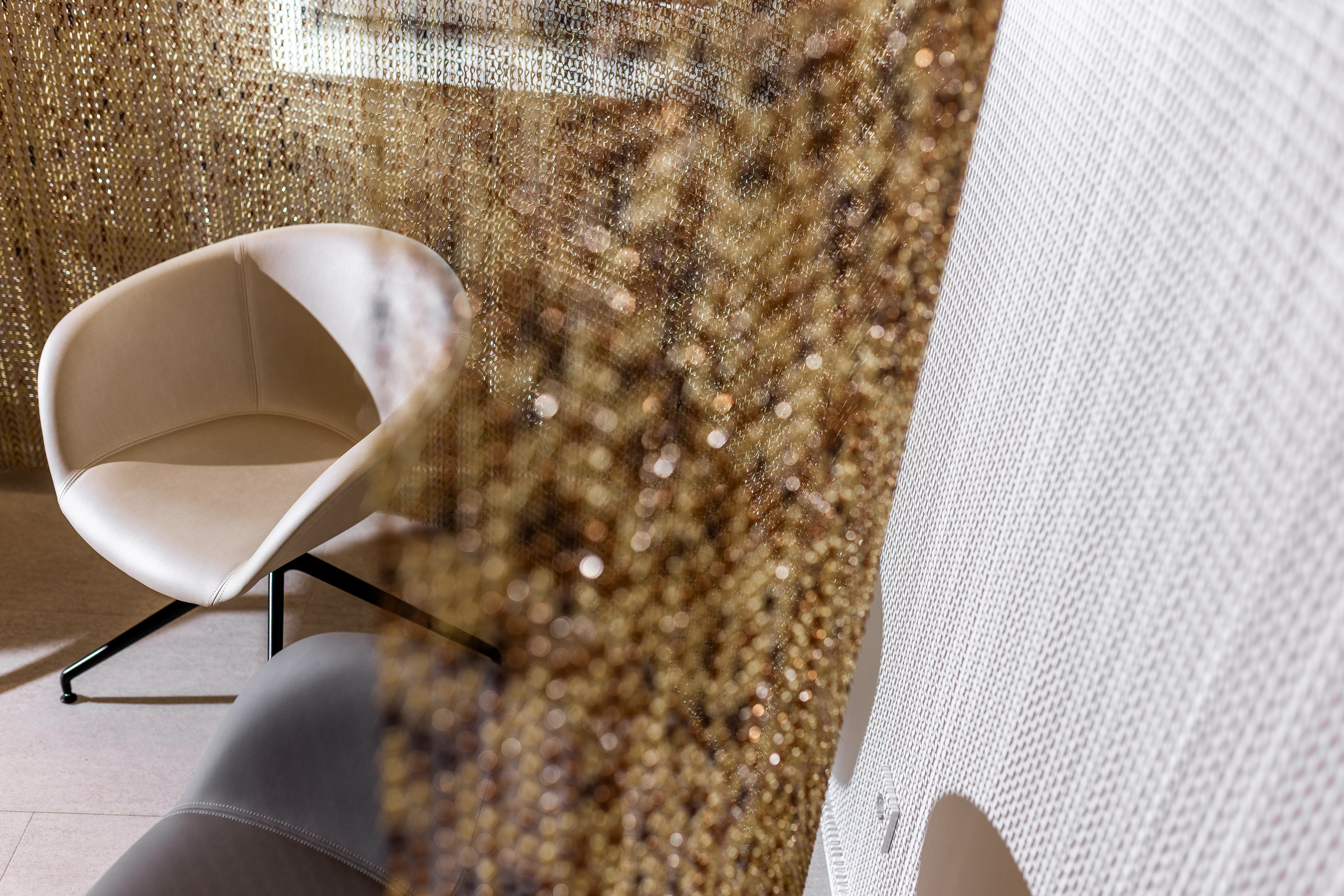 Stuhl im Wartebereich mit Abgrenzung sonderanfertigung aus Ketten mit Lichtspiel in Praxis