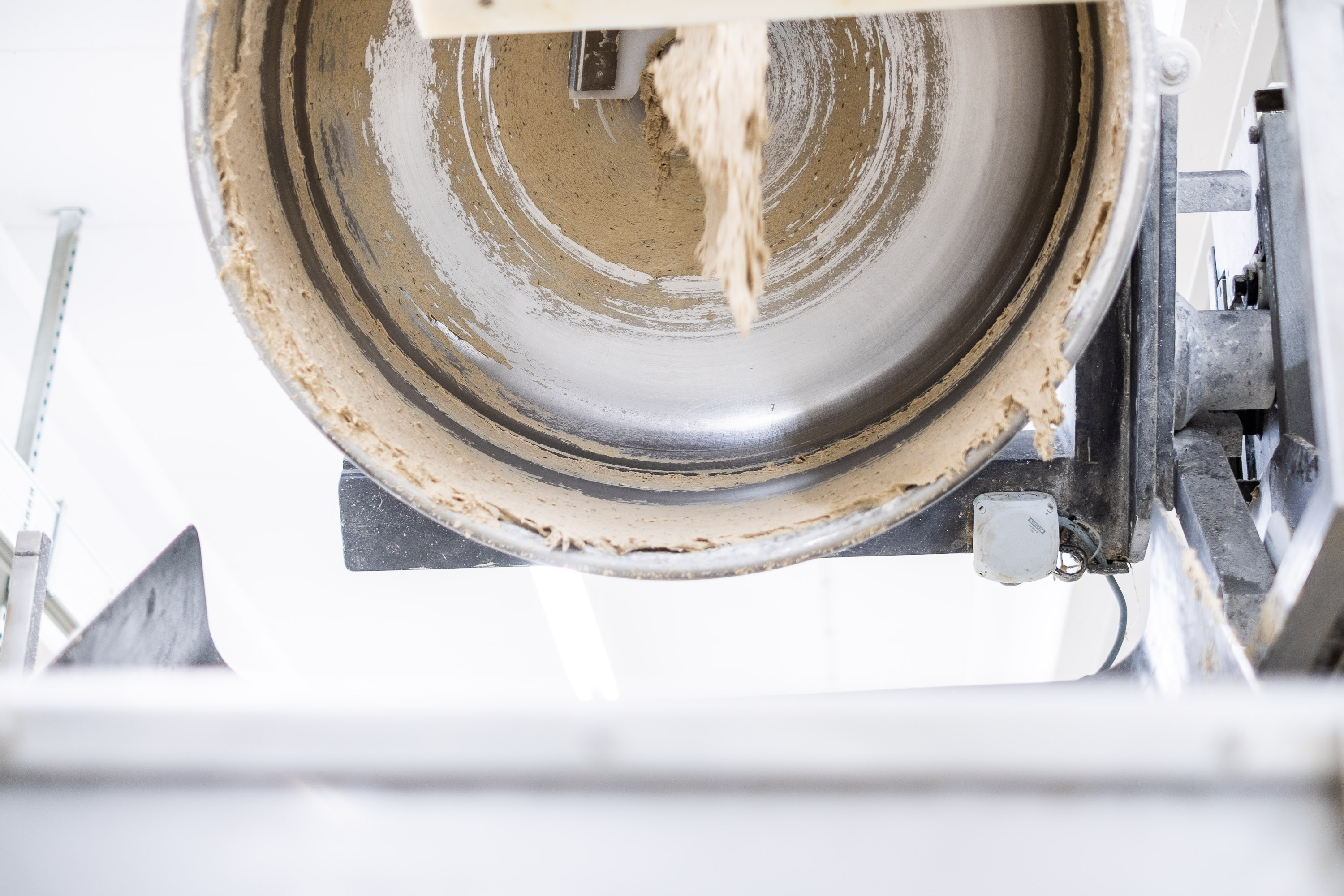 Reportage fotografie für Backerei und in der Backstube - Rührmaschine ist gekippt und Teig erste hängen darin