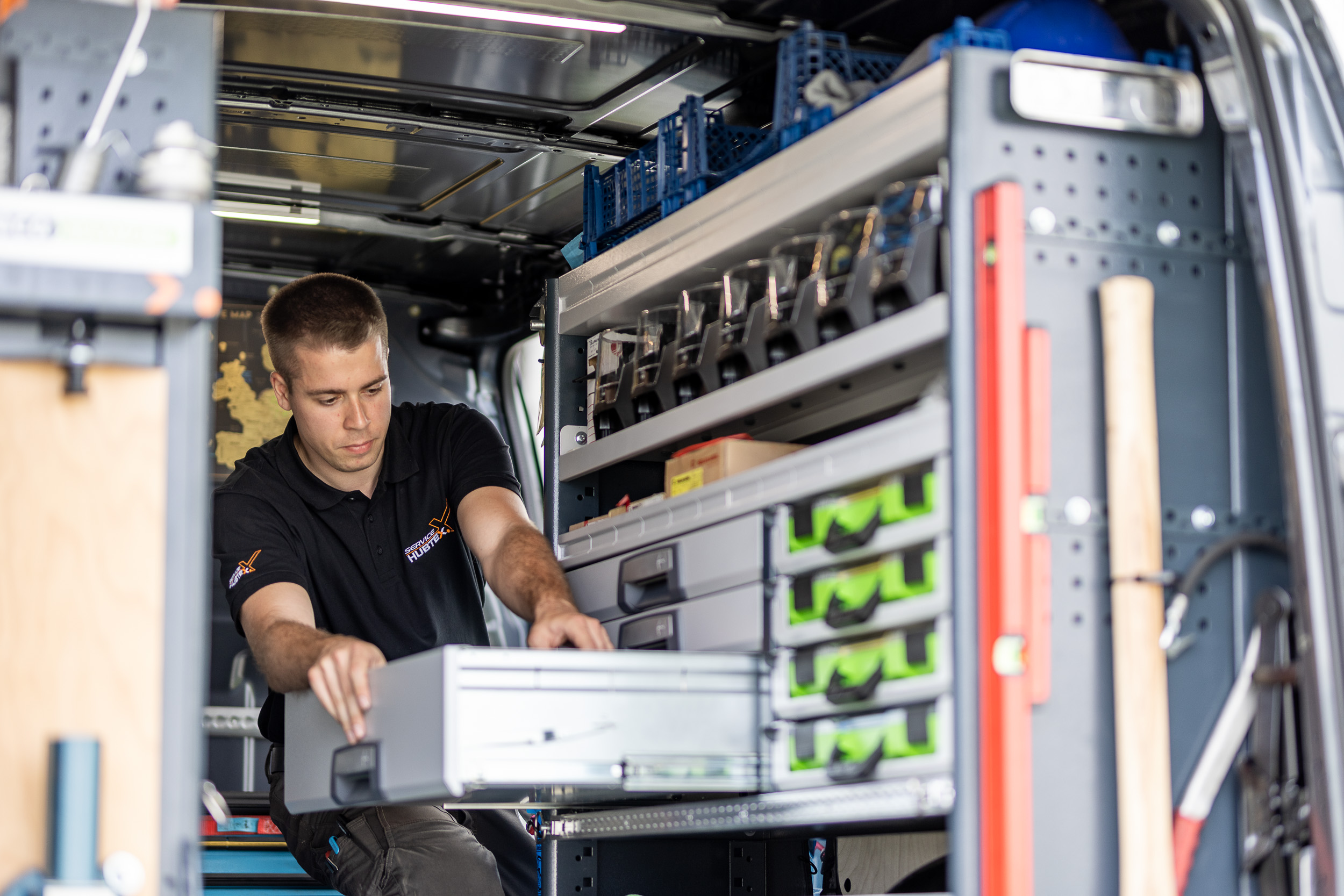 Hubtex Mitarbeiter arbeitet bei Fotoshooting für Service im Kundendienstfahrzeug