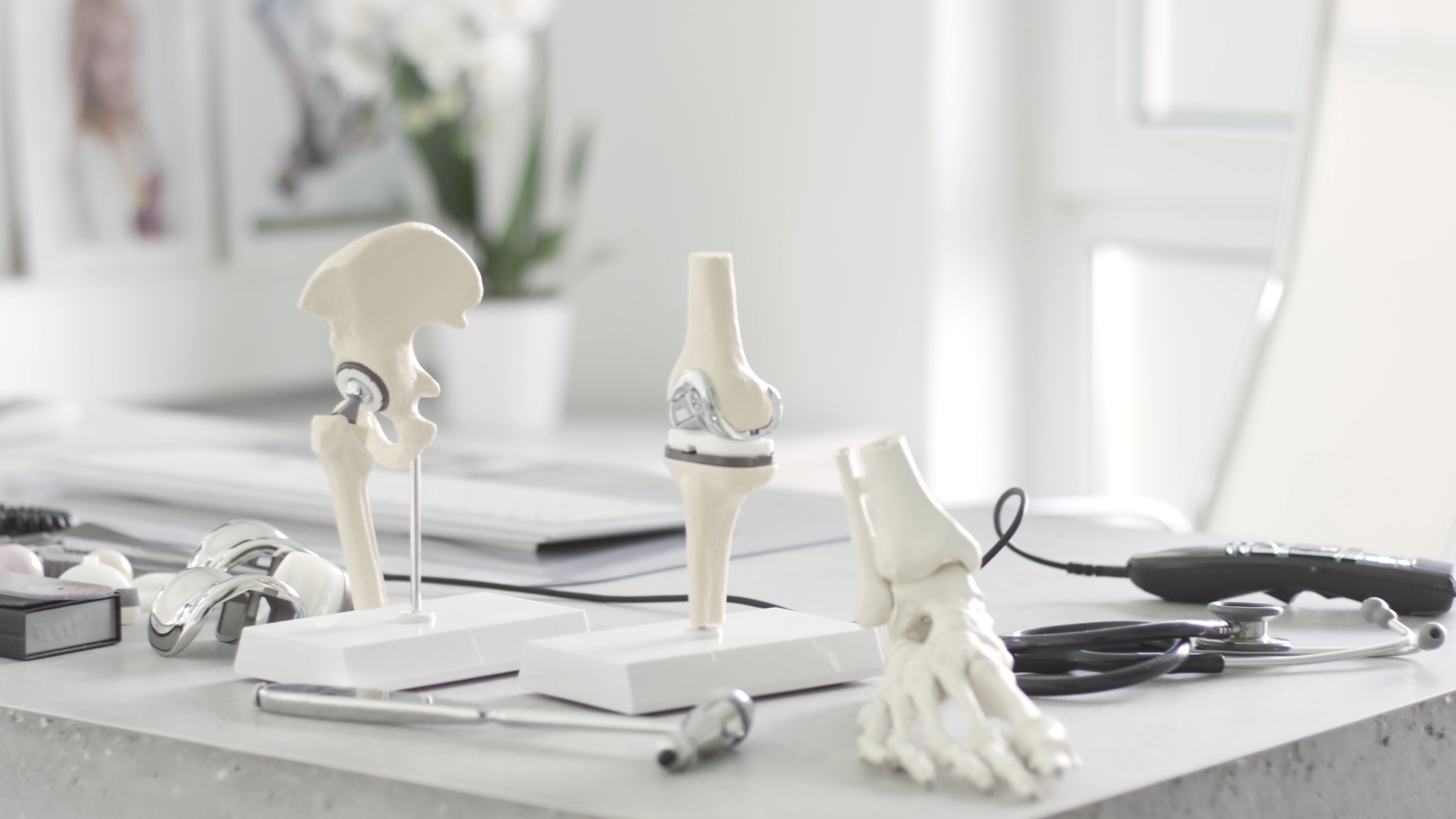 Schreibtisch einer modernen Arztpraxis mit Knochen und Beispielen - Praxis für Ortophädie