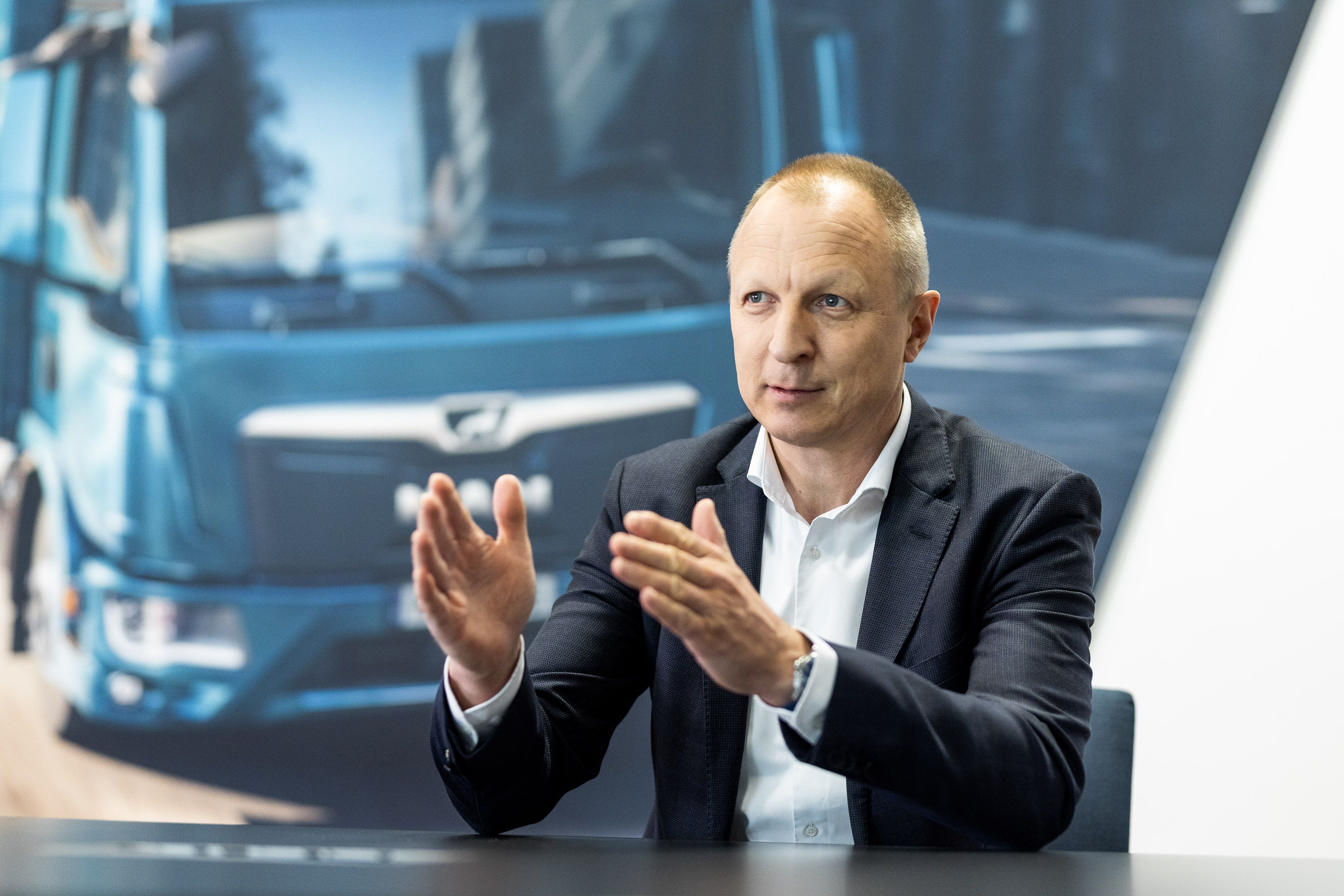 Klassisches PR Werbefoto - Content für Unternehmen Geschäftsführer sitz am Tisch und erklärt etwas
