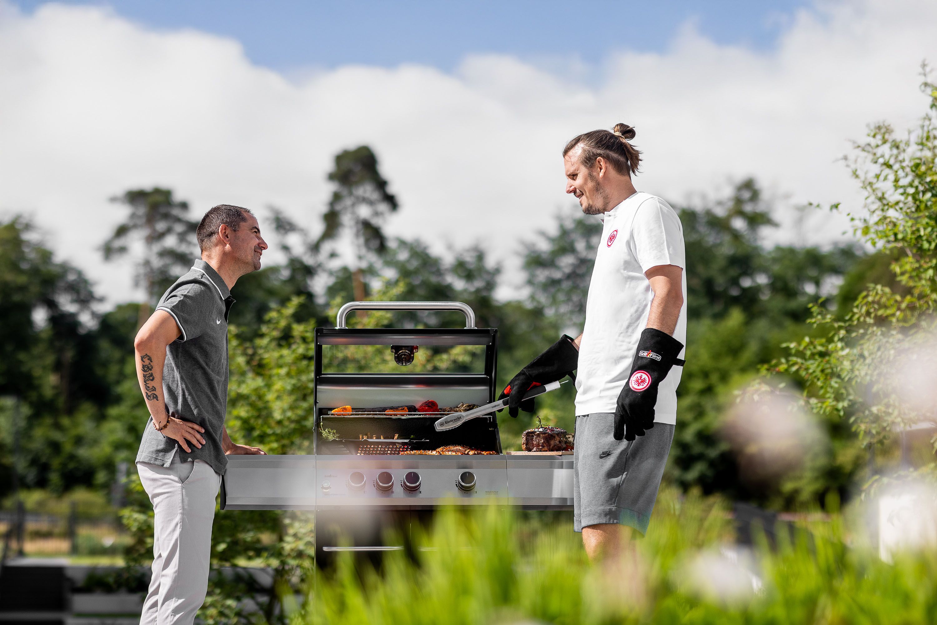 Detailaufnahme Grillzubehör – Contentproduktion für Grillfürst auf einem Tisch steht ein Dutch Oven und Gäste warten