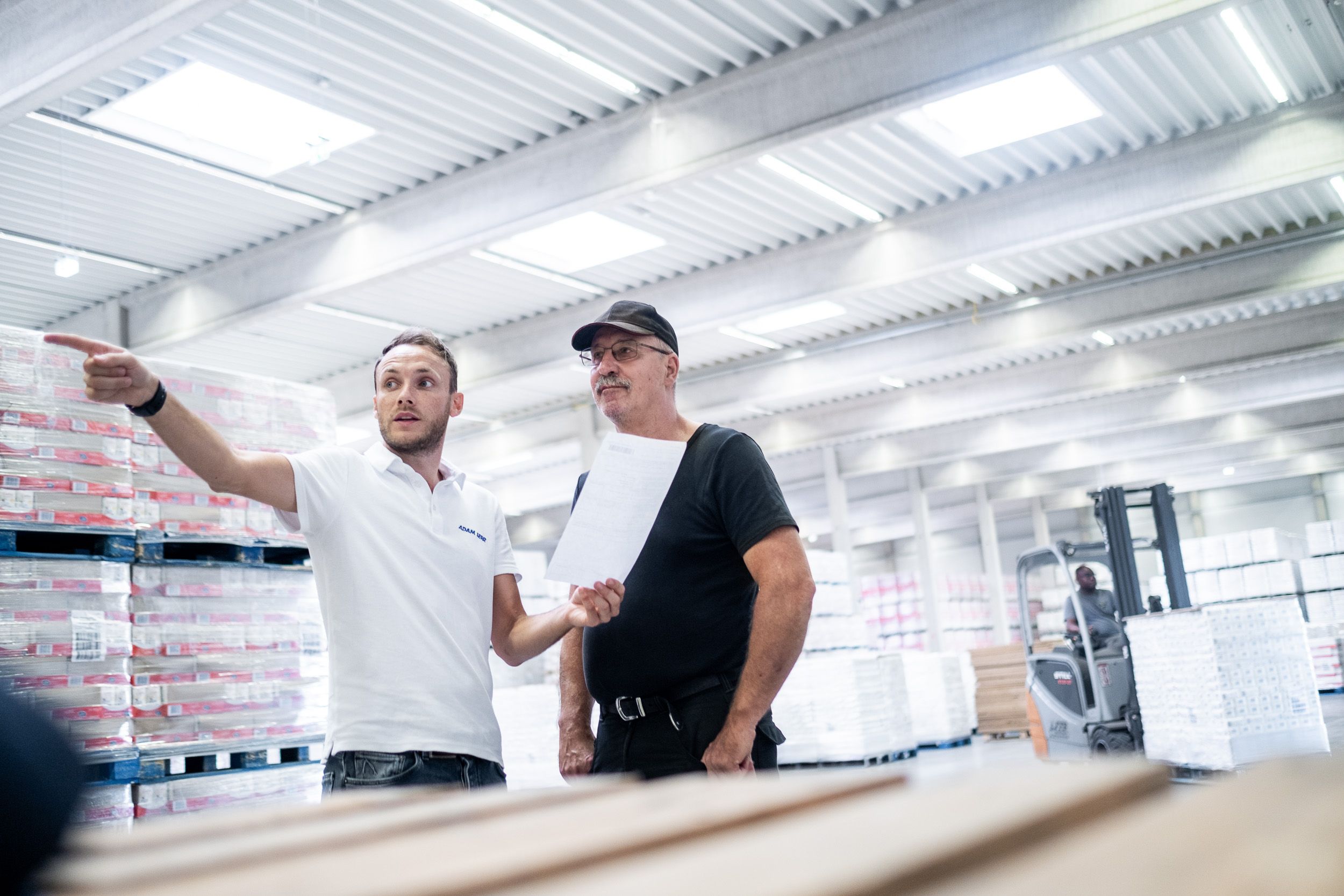 Adam Serr Mitarbeiter in der Logistikhalle – Teamwork & Contentproduktion