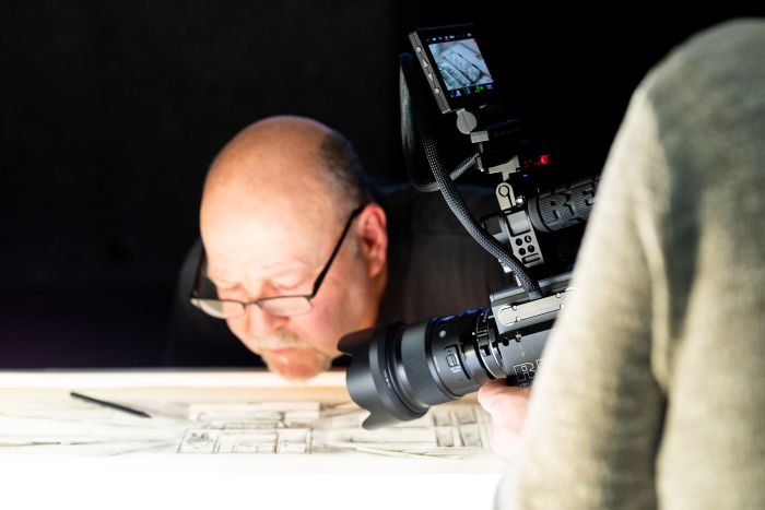 Filmdreh Imagefilm & Trailer - Maschinenbau und Industrie Unternehmen - Klaus Blechschmied zeichnet auf einem Blatt papier wird gefilmt mit Red Kamera