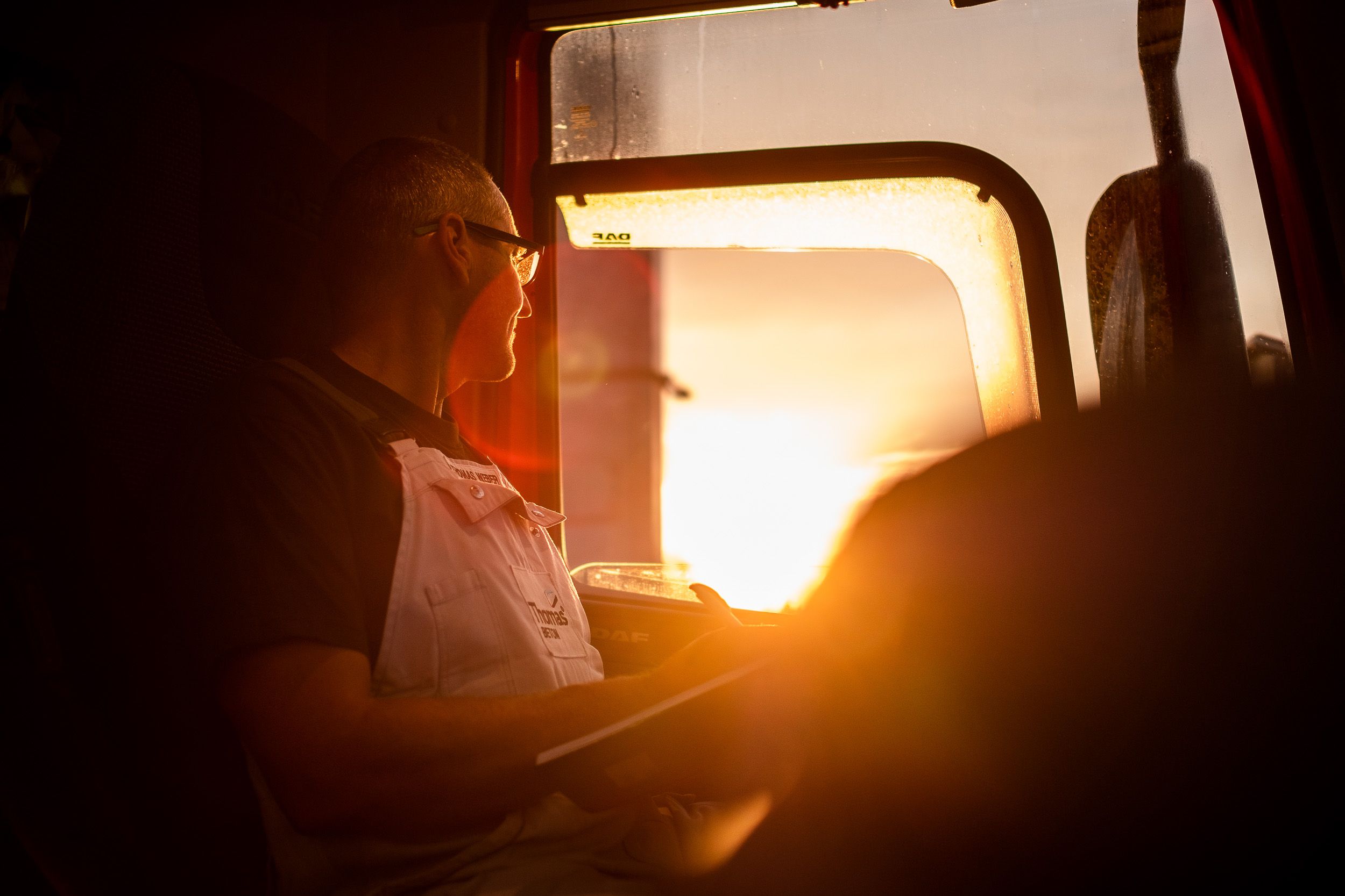 LKW fahrer schaut in Sonnenaufgang - Thomas Beton in Kiel Werbefotografie und FIlmproduktion