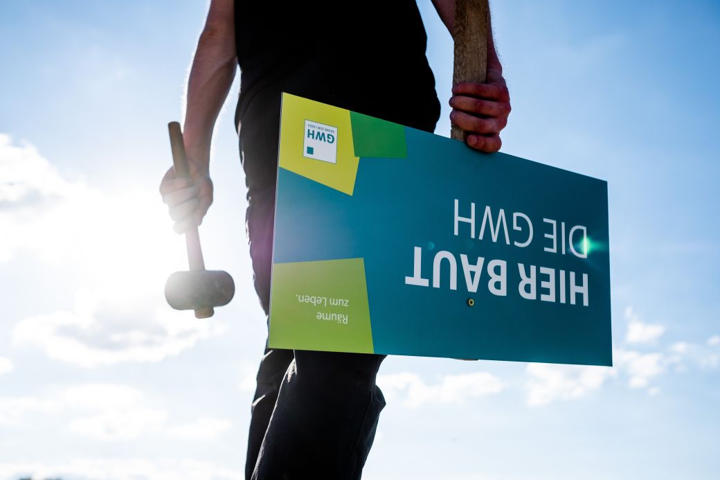 Hier baut die GWH - Schild mit Person und hammer