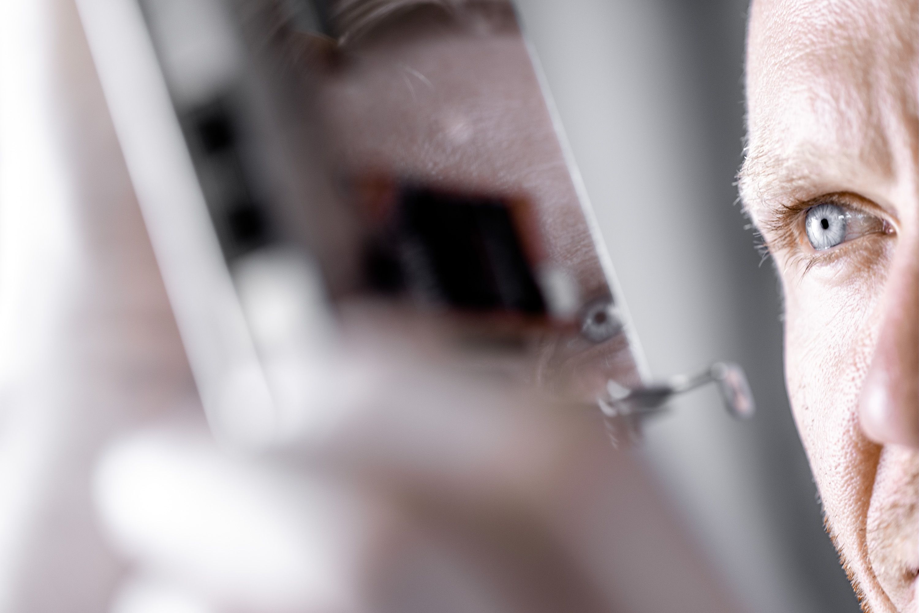 Person mit blauem Auge schaut bei Werbefotoshooting auf Chipkarte 