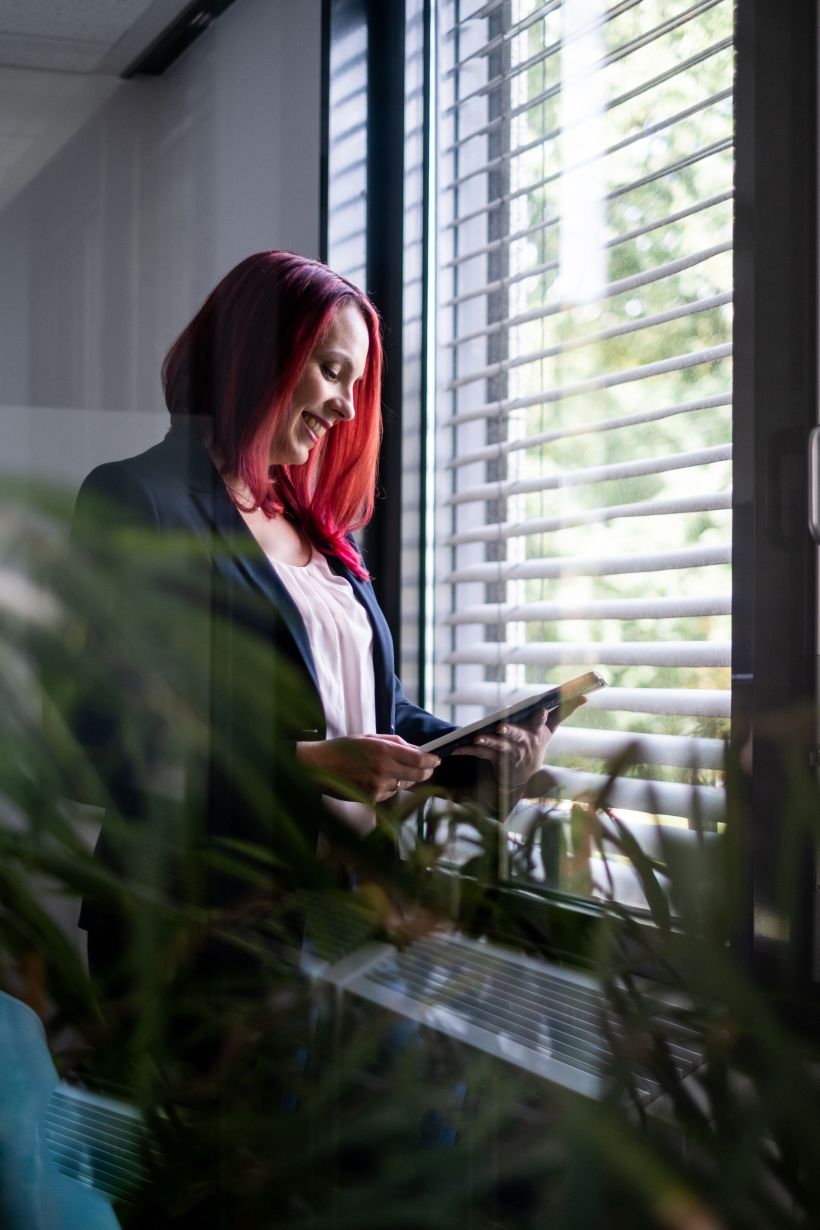 Employer Branding Kampagne: Authentische Mitarbeiterfotos an einem Fenster mit Ipad
